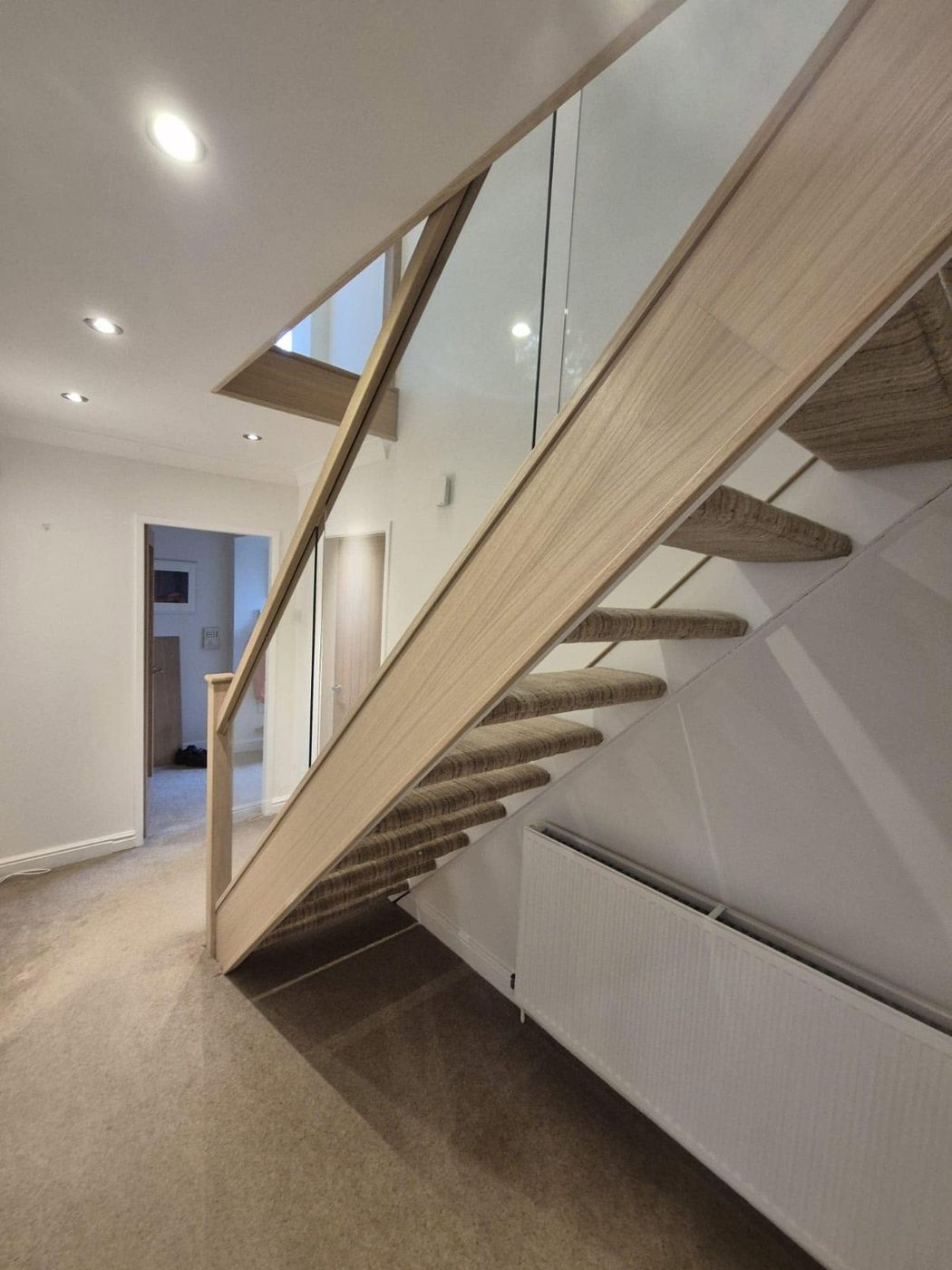 White and oak staircase with glass balustrade made by PJB joiners