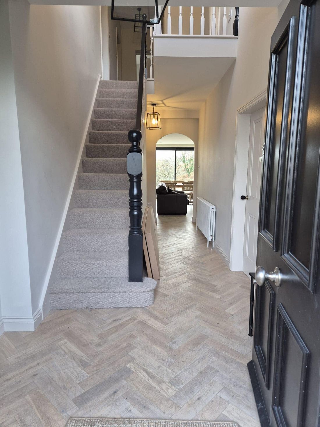 Renovated hallway with herringbone floor and refinished staircase